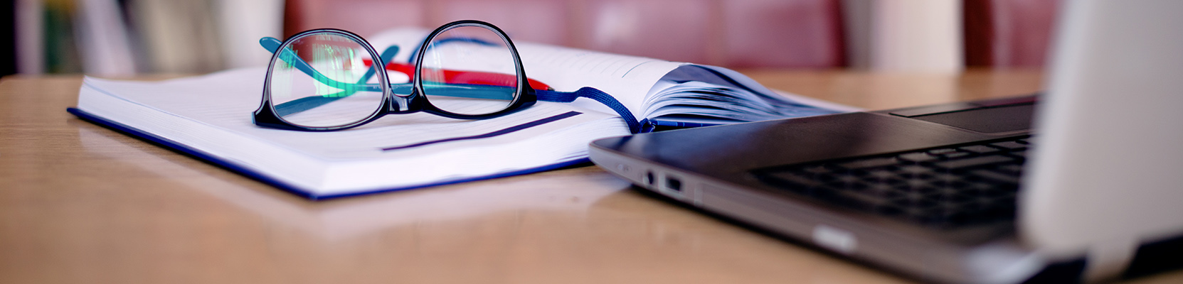 A laptop and notebook on a desk