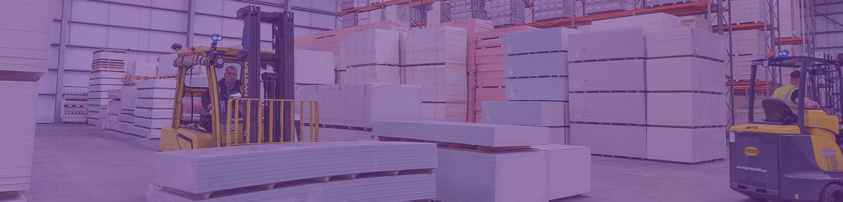 Forklift driver moving a pallet of plasterboard